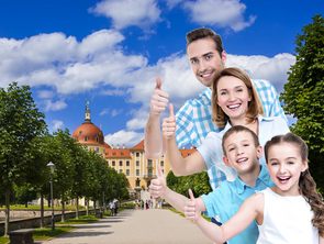 Einladung zur Besucherbefragung Eine Familie vor Schloss Moritzburg zeigt mit dem Daumen nach oben